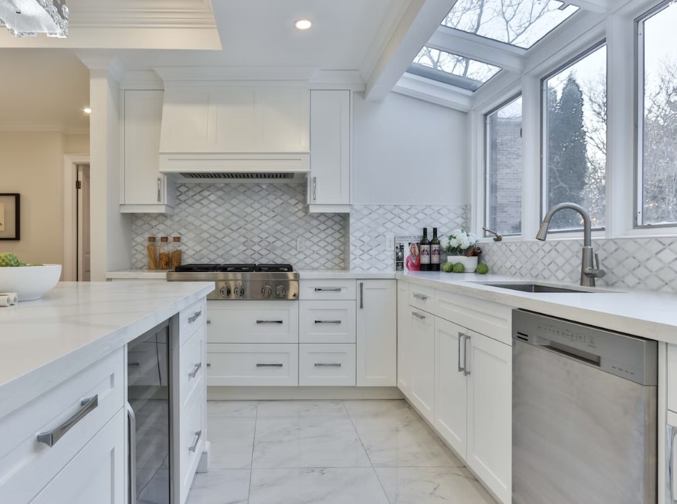White kitchen with large windows demonstrating light and a modern touch.